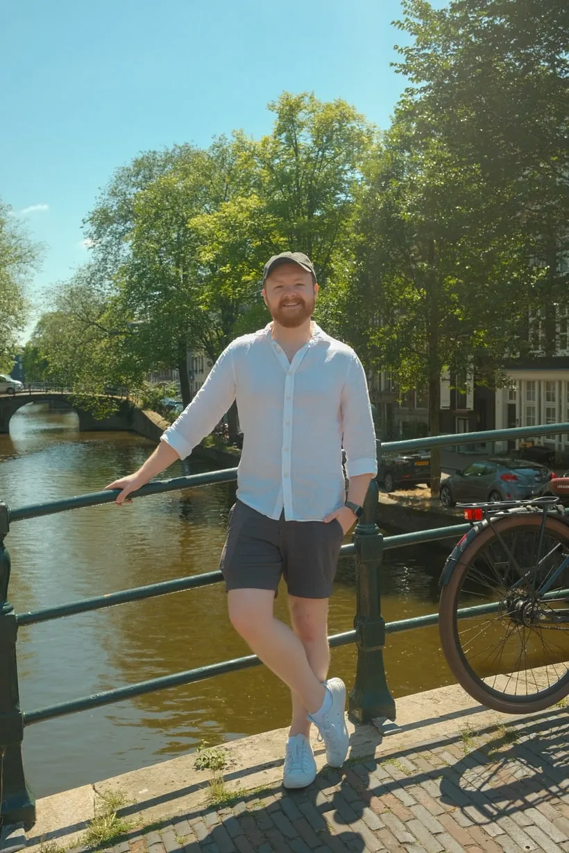Josh Hellawell, standing on a bridge over a canal on a sunny day