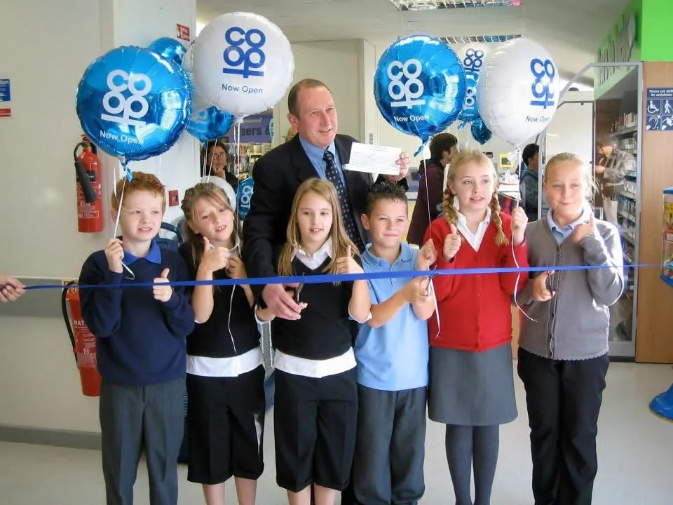 Me and other children in school uniform cutting the ribbon to open a new Co-op store
